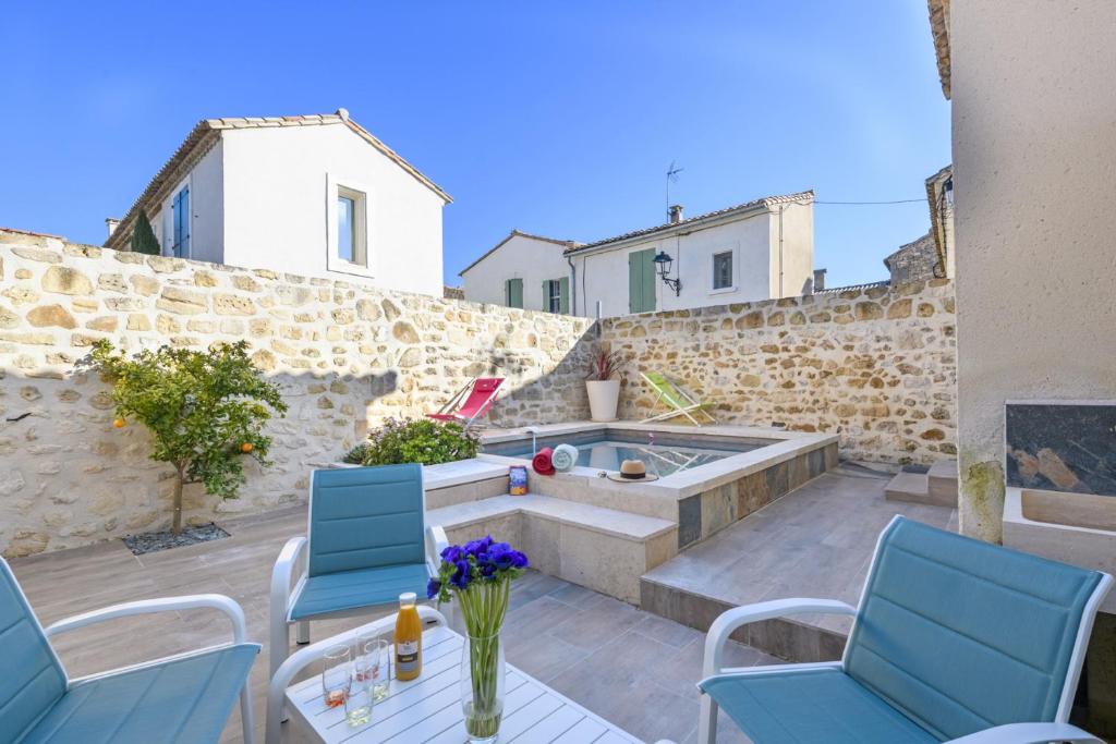 d'une terrasse avec un bain à remous et des chaises bleues. dans l'établissement Le Louzoane, à Maussane-les-Alpilles