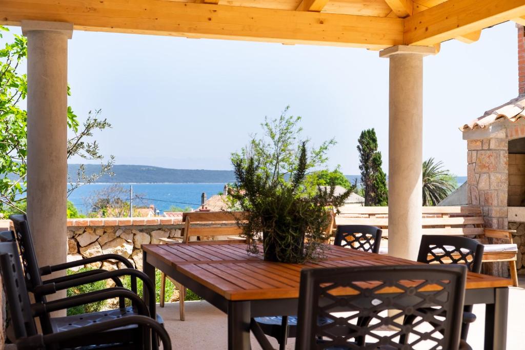 a wooden table and chairs on a patio with a view of the ocean at Apartment Mirna in Nerezine