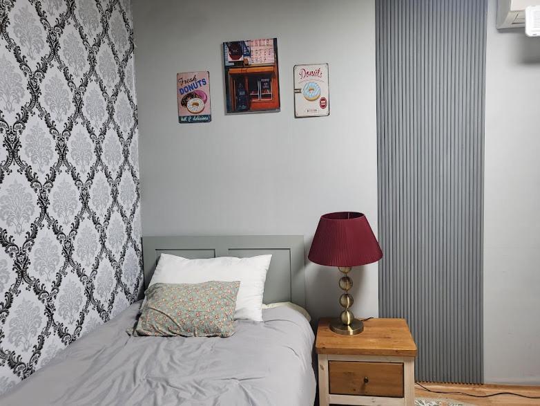 a bedroom with a bed and a table with a lamp at Casa de Minrak in Busan