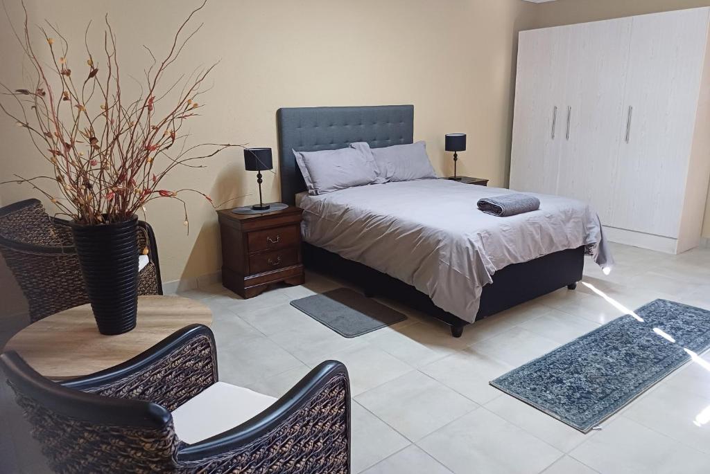 une chambre avec un lit, une table et des chaises dans l'établissement Corea Game Ranch, à Alldays