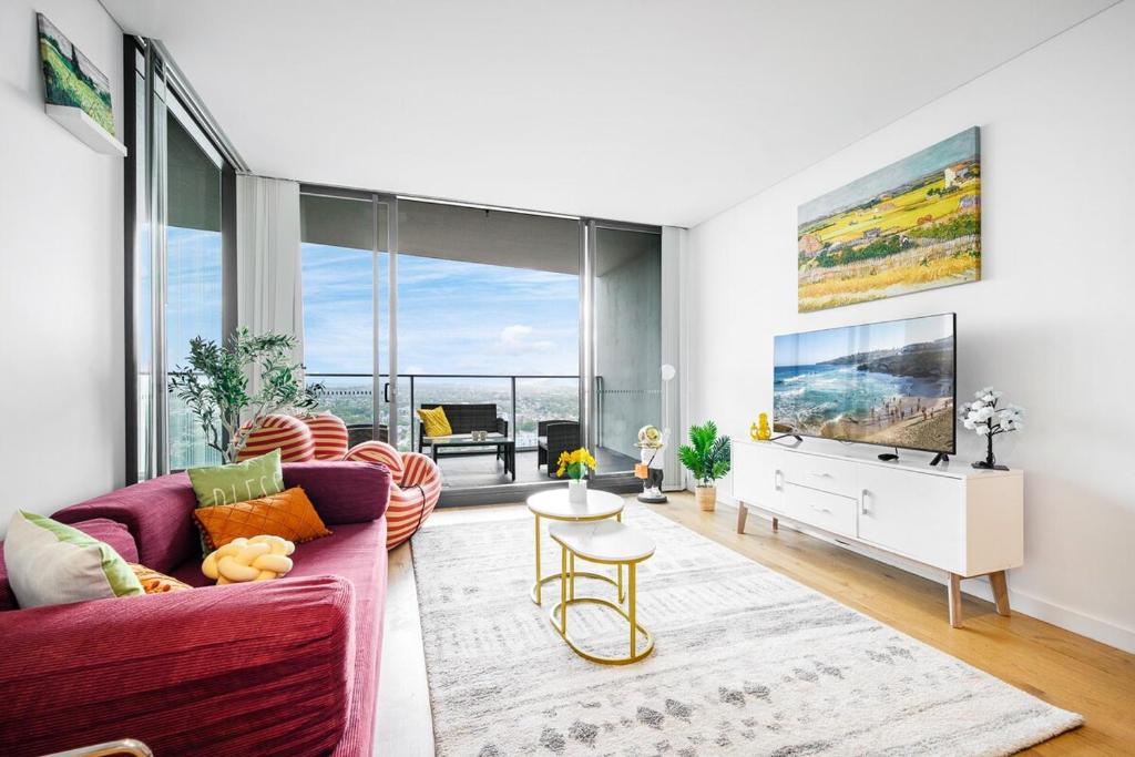 a living room with a purple couch and a tv at Luxury 2Br Apt Near Train Shopping Center in Sydney