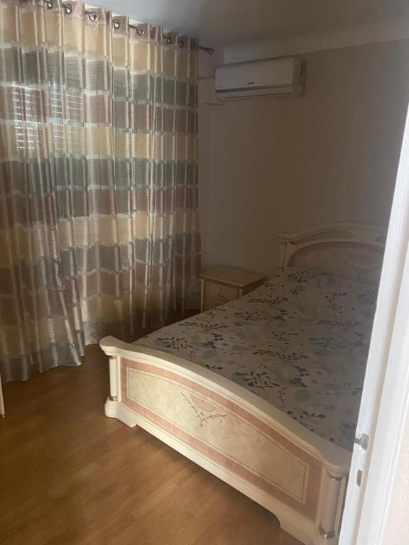 - une chambre avec un lit dans une pièce dotée d'un rideau dans l'établissement Maison Canet village, à Canet
