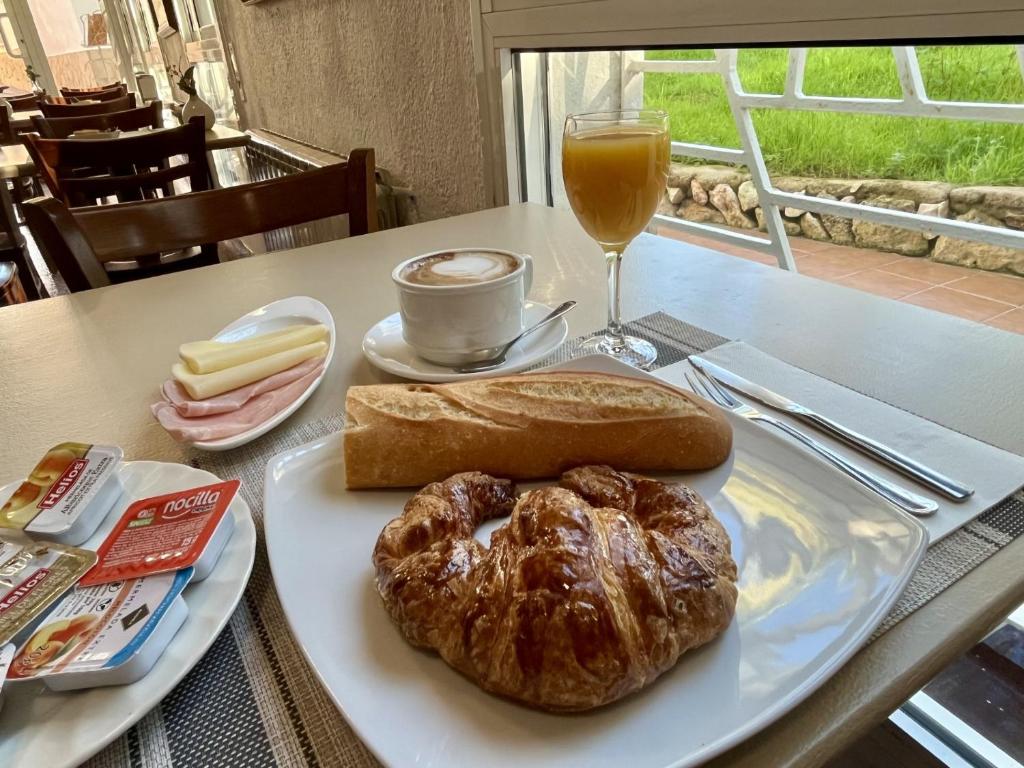 a table with a plate of bread and a glass of orange juice at Hotel Oreneta in Altafulla