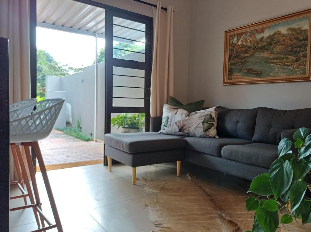 ein Wohnzimmer mit einer Couch und einem Sessel in der Unterkunft Buckingham Cottage in Pinetown