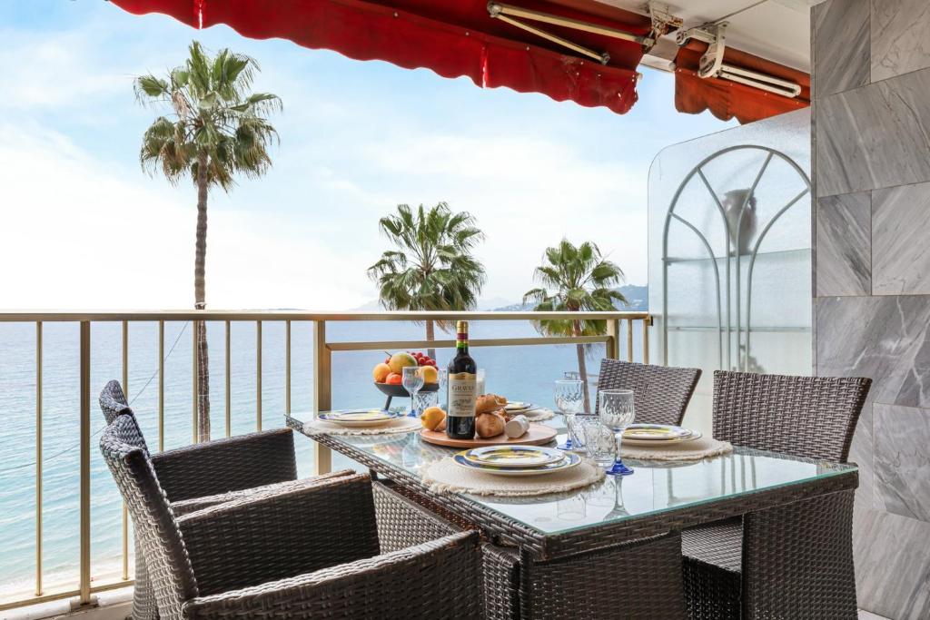 - une table sur un balcon avec vue sur l'océan dans l'établissement Suite Bleu Vue Mer Confort à Juan-les-Pins, à Antibes