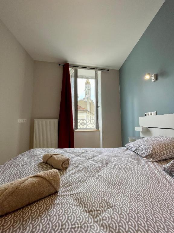 une chambre avec un grand lit et une fenêtre dans l'établissement Appart'Village Le vieux Vichy centre T1,T2,T3 - Parking - Thermes, à Vichy
