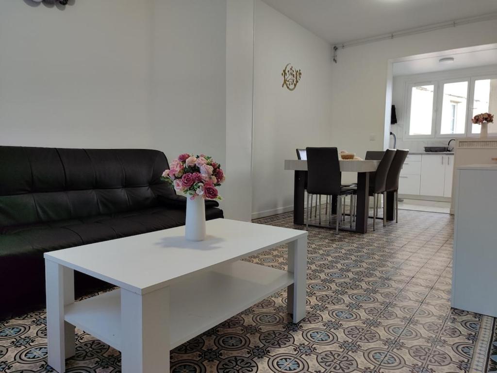 a living room with a couch and a table with flowers on it at Entire home - Centre Fécamp - 45 Rosa in Fécamp