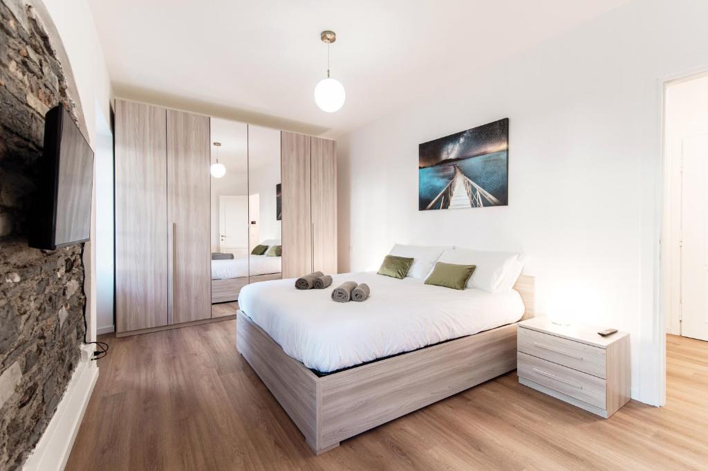 a bedroom with a large white bed and a fireplace at Sunflower Apartment -The House Of Travelers in Como