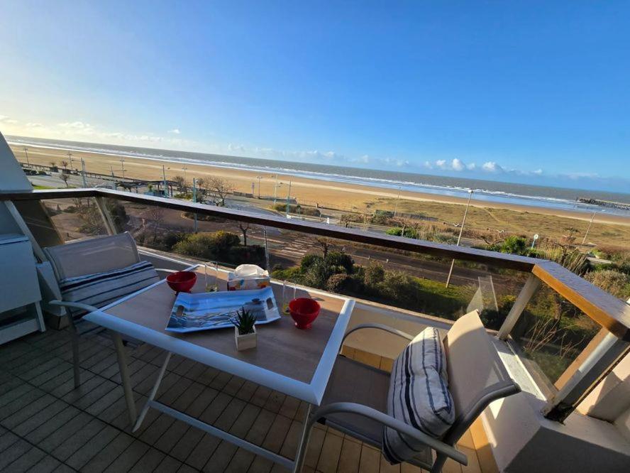 - un balcon avec une table et des chaises et la plage dans l'établissement Joli studio face mer et estacade, à Saint-Jean-de-Monts