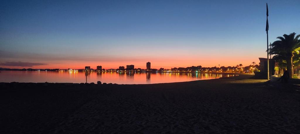 a sunset over a body of water with a city at Piso Bosique in San Pedro del Pinatar