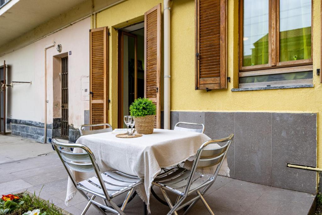 een tafel met een wit tafelkleed en stoelen bij Cozy Flat with Private Garden in Paderno Dugnano