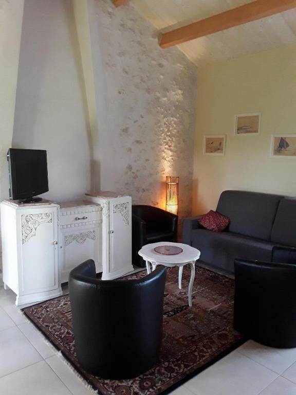 un salon avec un canapé et une table dans l'établissement La Longère des Basses Terres, à La Garnache