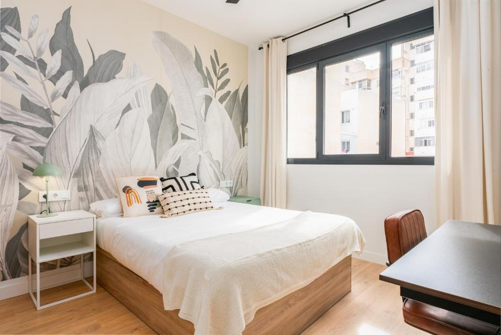 a bedroom with a bed and a large window at Live It Malaga in Málaga