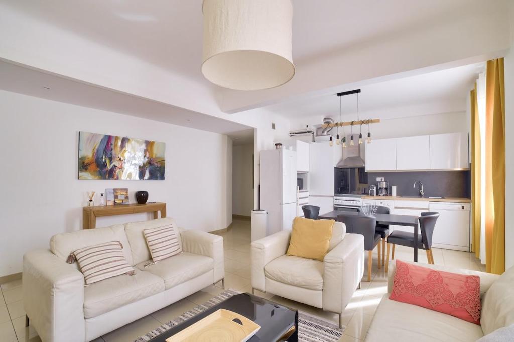 Il comprend un salon avec un mobilier blanc et une cuisine. dans l'établissement Stunning 2BR by the Port 20min Walk to the Beach, à Nice