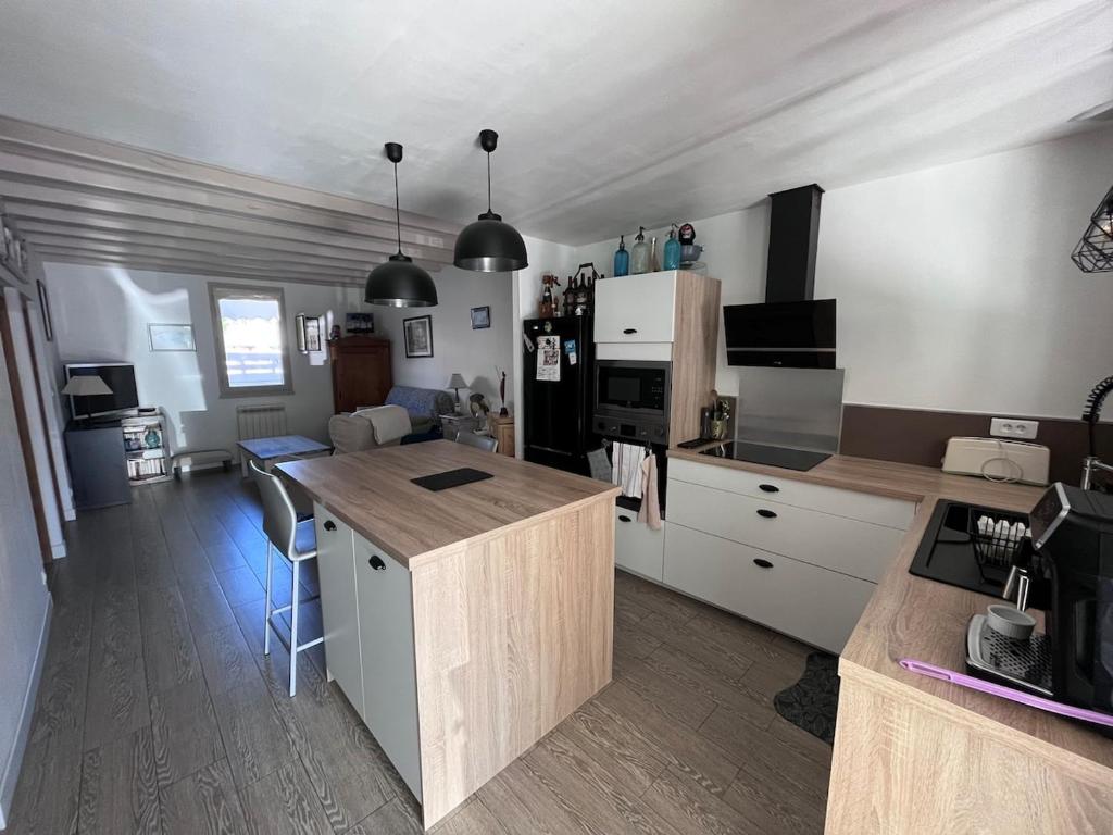 une cuisine avec des armoires blanches et un comptoir dans l'établissement La Brémontine, à Parentis-en-Born