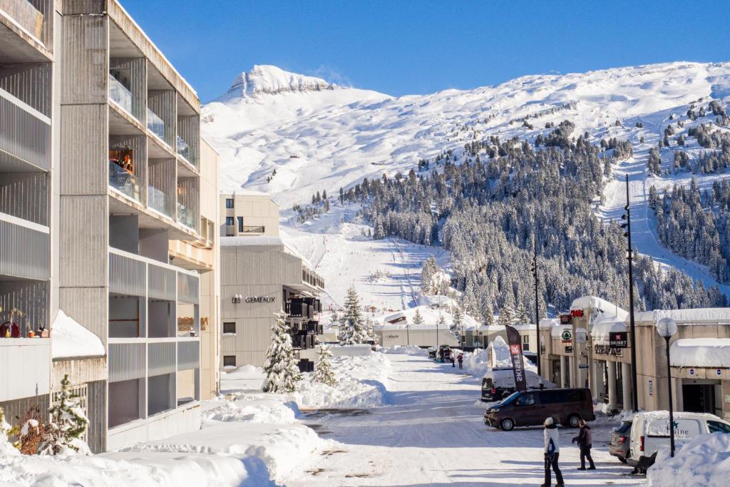 a snow covered mountain in front of a building at Appartement Flaine Forêt in Flaine