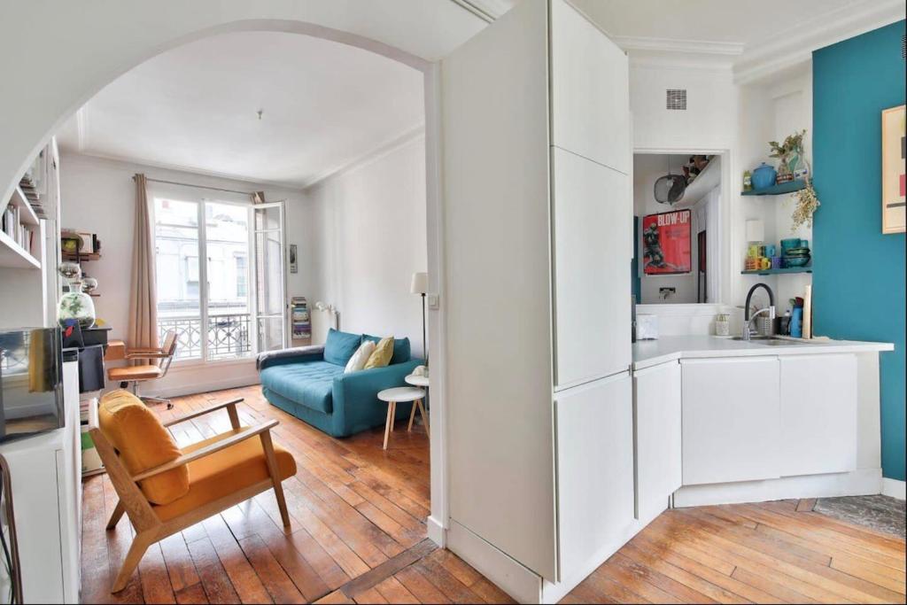 Il comprend une cuisine et un salon avec un canapé bleu. dans l'établissement superbe appartement place république, à Paris
