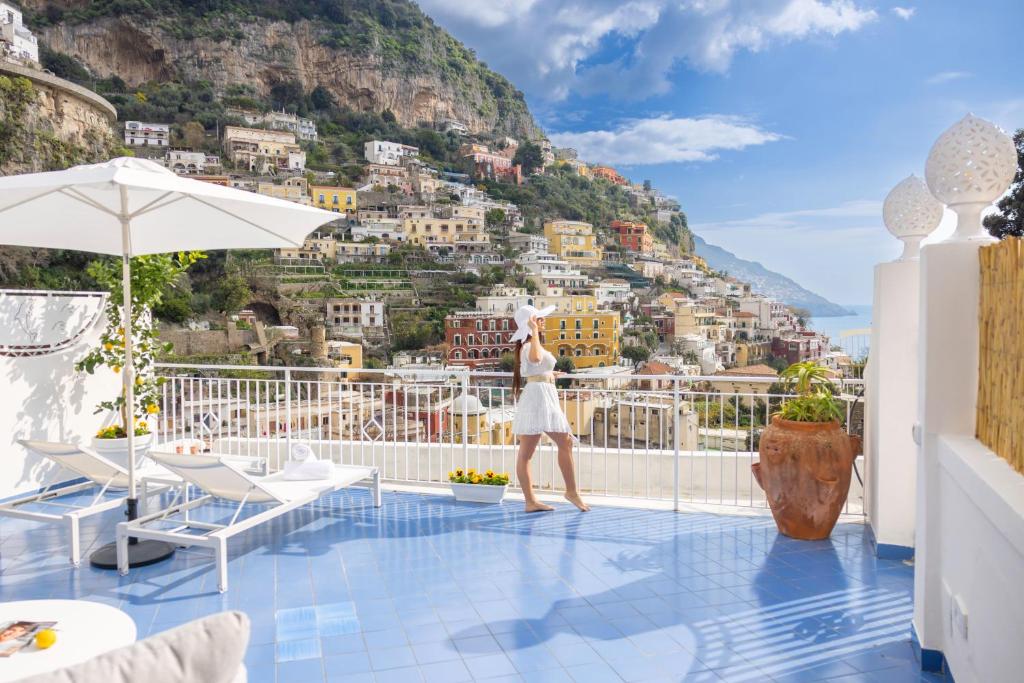 ポジターノにあるYourHome - Villa Magnificaの市街の景色を望むプールを歩く女性