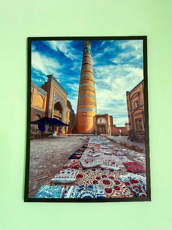 a picture of a tower with a rug on the ground at Mahdiy Hotel in Khiva