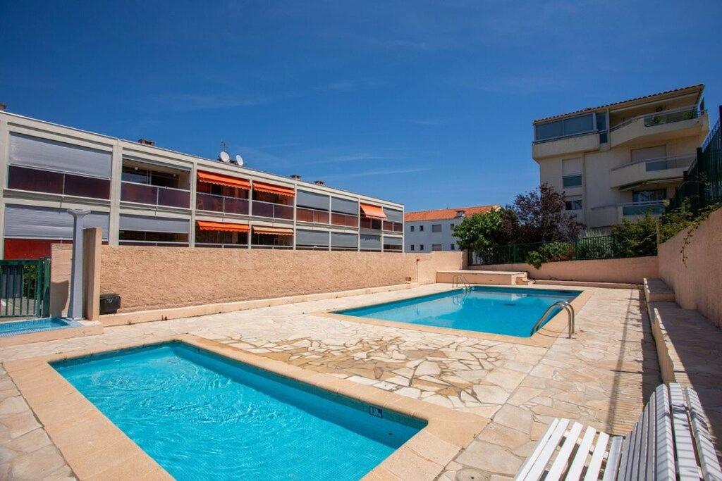 2 piscines en face d'un bâtiment dans l'établissement L'escapade salée - Saint Aygulf, à Fréjus
