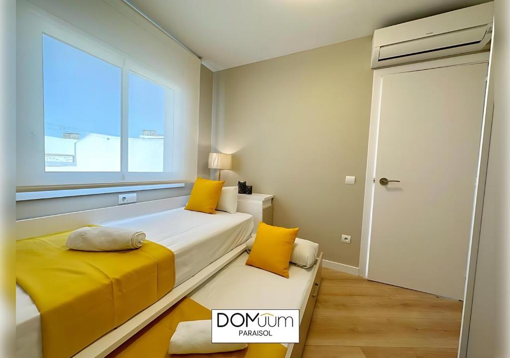 A bed or beds in a room at DOMuum Holidays - PARAISOL Family Home