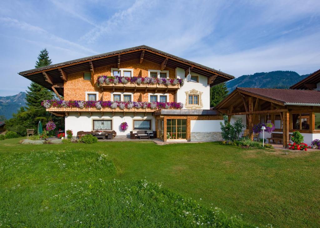 una casa grande con flores en el balcón en Tyroler Hof, en Grän