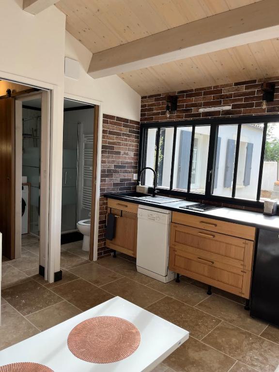 - une cuisine avec un lavabo et des toilettes dans la chambre dans l'établissement Appartement neuf proche de la rochelle, à Puilboreau