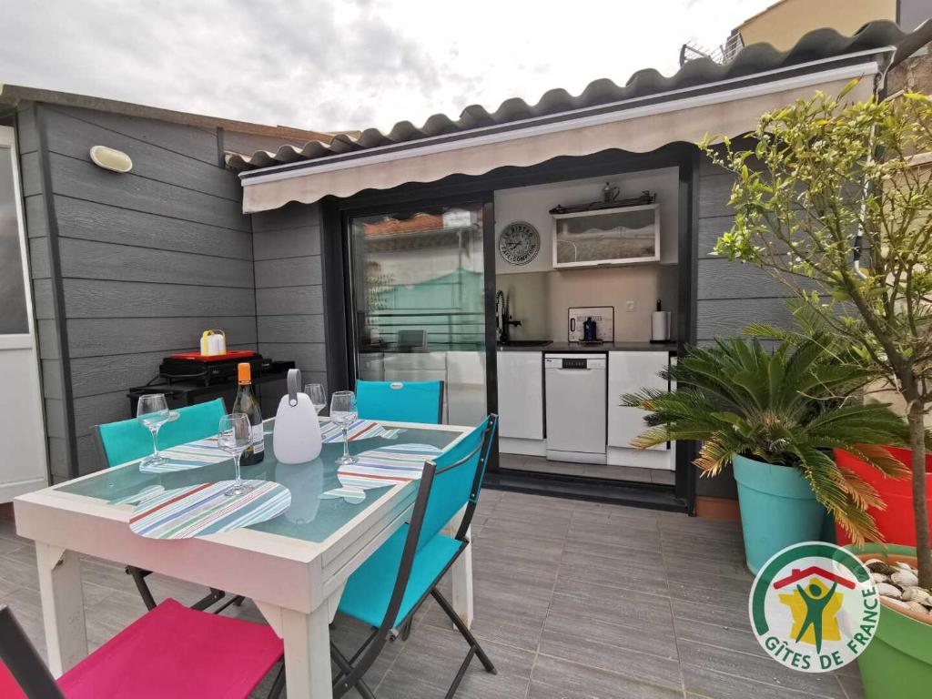 a table and chairs on a patio with a kitchen at Gite la tropezienne in Marseillan