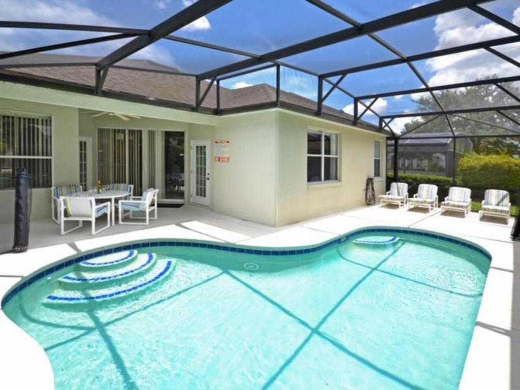 a large swimming pool with a patio with a table and chairs at Orlando Theme Park Pool Homes in Kissimmee