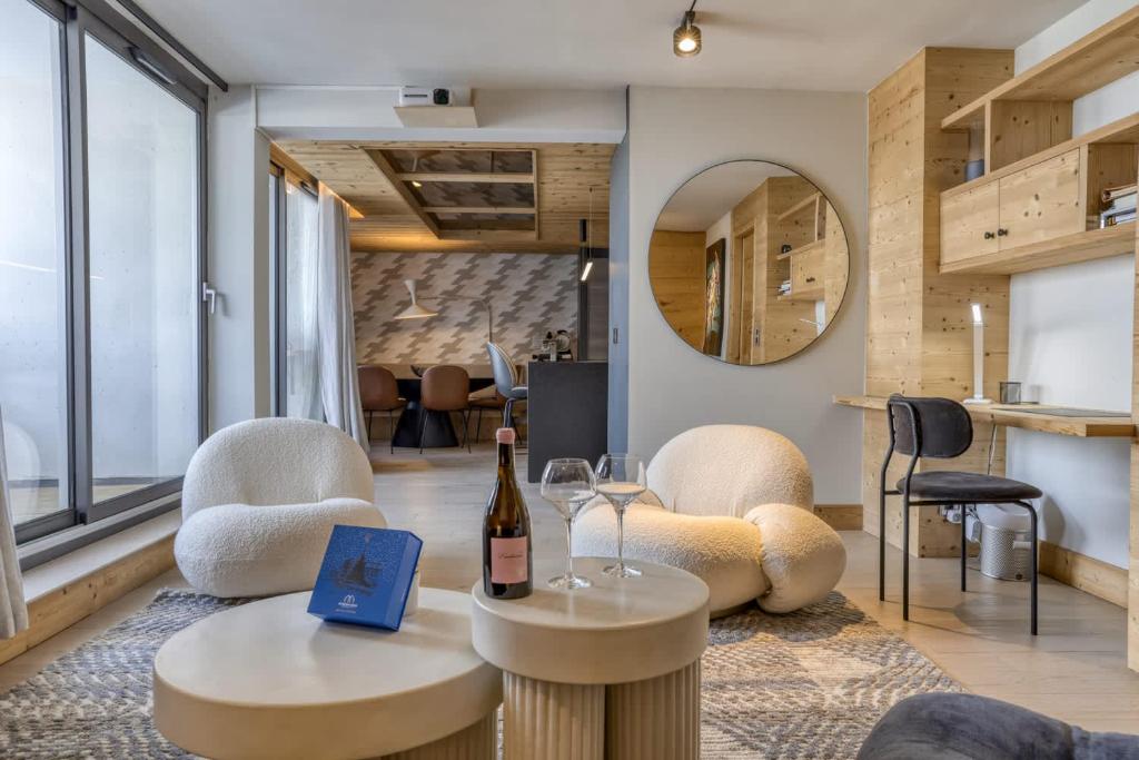 - un salon avec deux chaises et une bouteille de vin dans l'établissement Megeve les skis aux pieds, à Megève