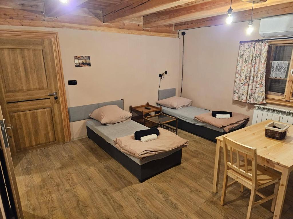 Pokój z dwoma łóżkami i stołem w obiekcie Apartament Rynek 30 w mieście Osieczna
