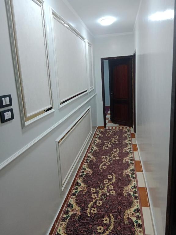 a hallway with a rug on the floor and two windows at الشريف للشقق الفندقيه in Abu Simbel