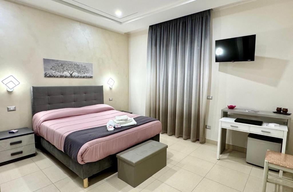 a hotel room with a bed and a television at MIRO'S Casa Vacanze Pompei in Pompei