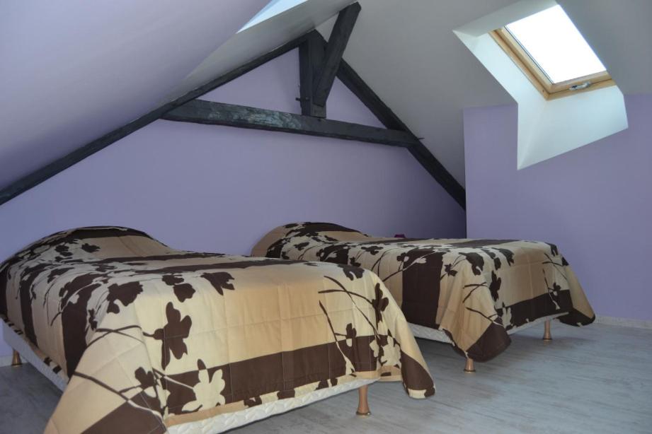 two beds in a room with purple walls at Résidence Baie de Seine in Le Havre
