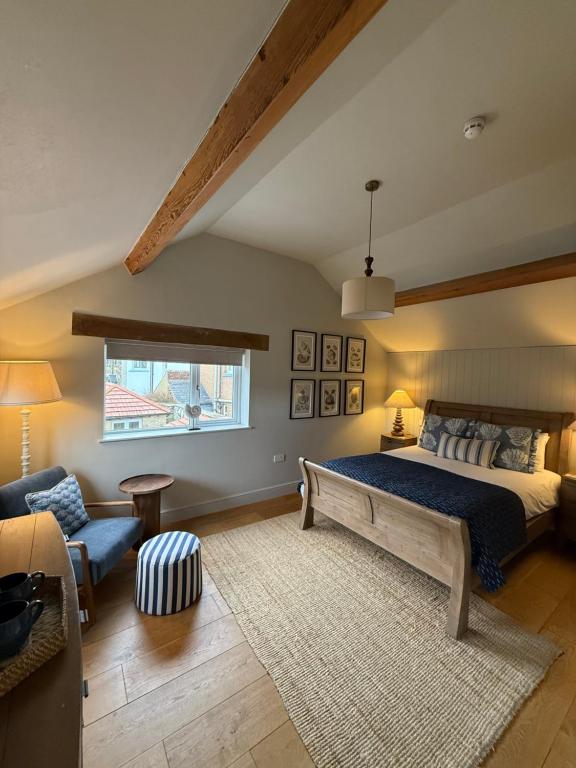 a bedroom with a bed and a couch and a window at The Red Lion Inn Alnmouth in Alnmouth
