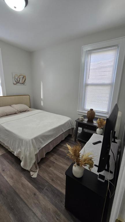a bedroom with a bed and a table and a window at Serenity Haven in Irvington