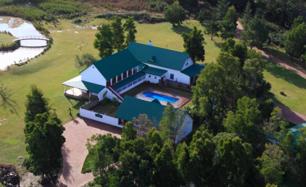 L'Heritage Retreat في Wildernis: اطلالة جوية على بيت ابيض كبير بسقف اخضر