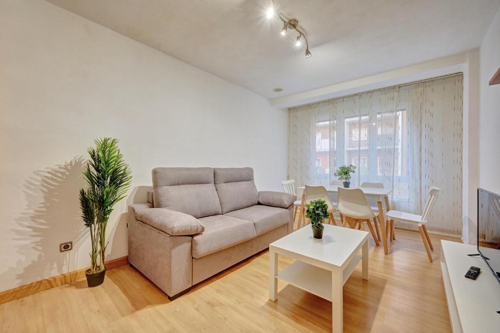 ein Wohnzimmer mit Sofa und Tisch in der Unterkunft El Encanto de Huesca by Clabao in Logroño