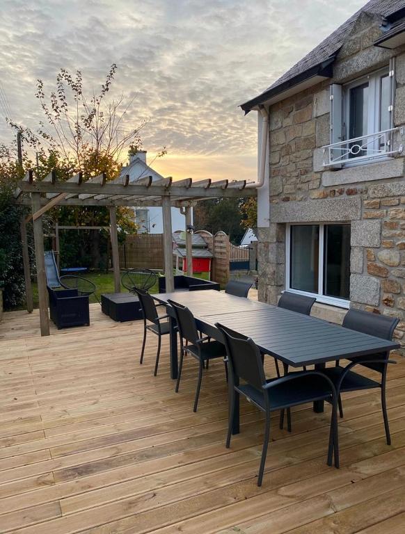 une table et des chaises sur une terrasse avec pergola dans l'établissement Charmante maison proche de la mer et des commerces, à Trégunc