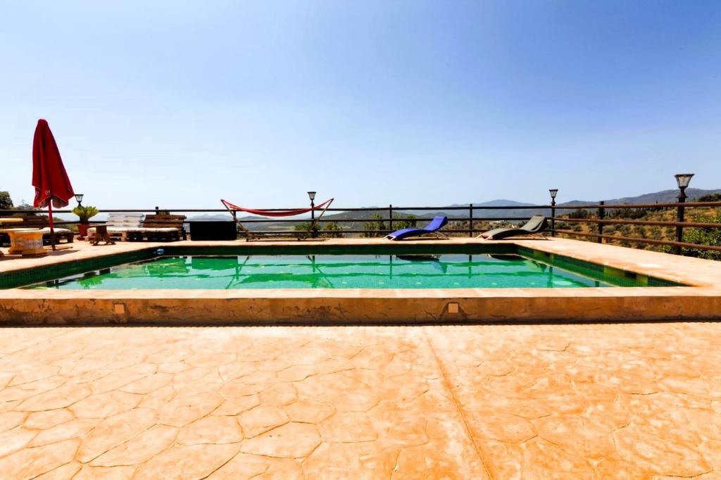 ein Swimmingpool mit grünem Wasser in der Mitte in der Unterkunft Casa rural con barbacoa y piscina in Ríogordo