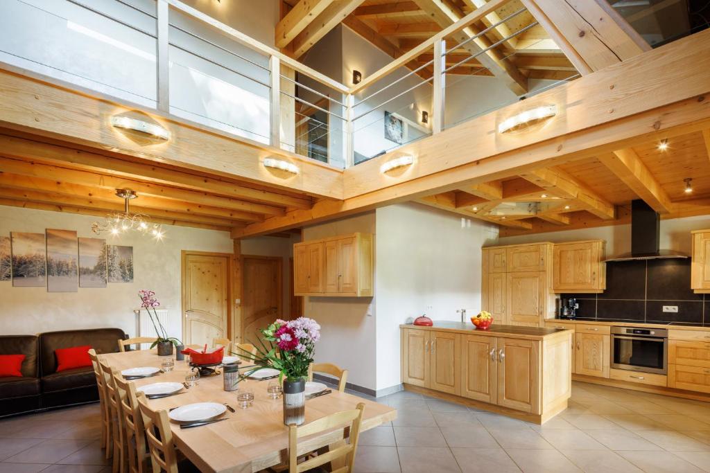 une grande cuisine avec une grande table en bois et des fleurs. dans l'établissement La Tourbière, à Entre-Deux-Monts