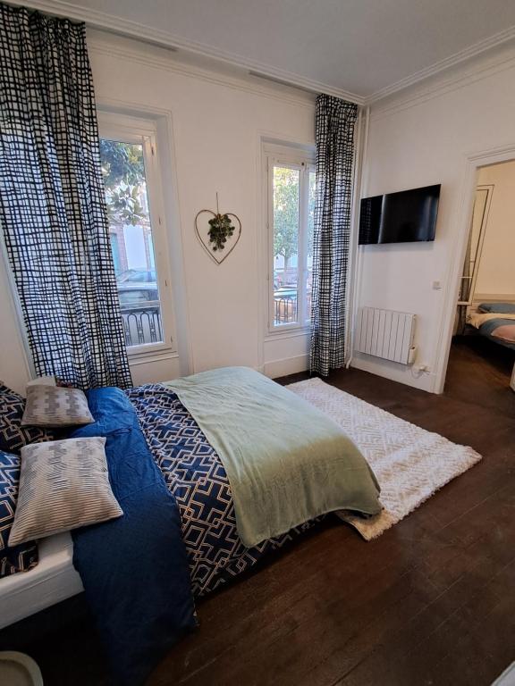 une chambre avec un lit, une télévision et des fenêtres dans l'établissement Centre, à Dreux