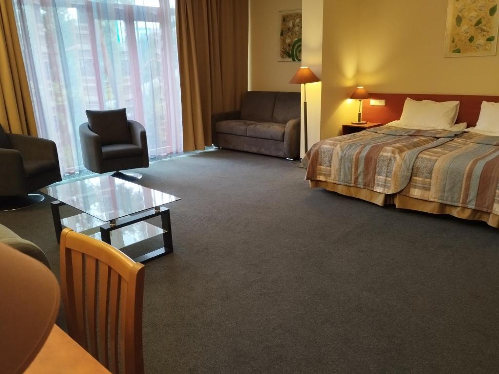 Postel nebo postele na pokoji v ubytování Perkuno Namai Park Hotel