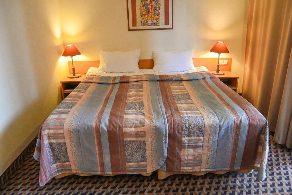 Postel nebo postele na pokoji v ubytování Perkuno Namai Park Hotel