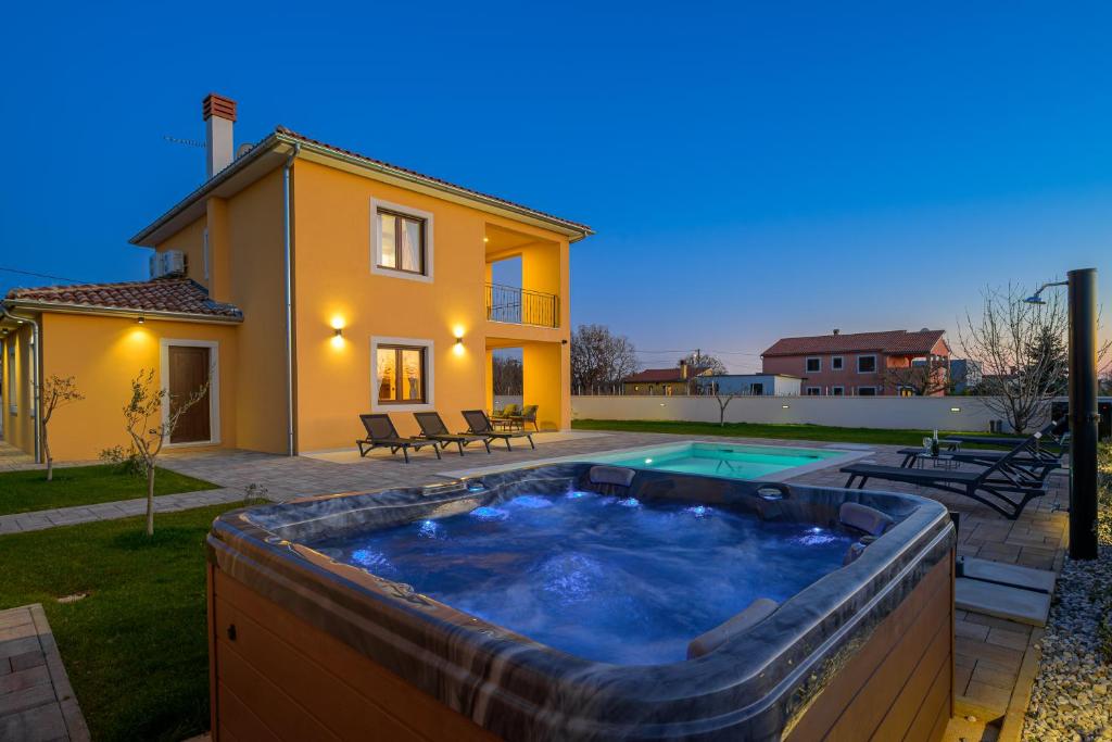 a backyard with a hot tub in front of a house at Villa Brajde by IstriaLux in Gajana