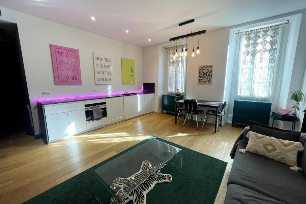 - un salon avec une table en verre dans l'établissement Grand studio design au coeur de Nice, à Nice