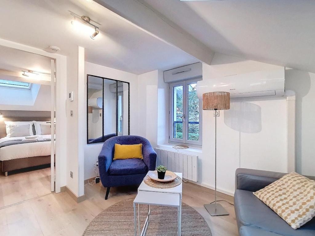 - un salon avec un fauteuil bleu et un canapé dans l'établissement Appartement Villa Cosy, à La Tronche