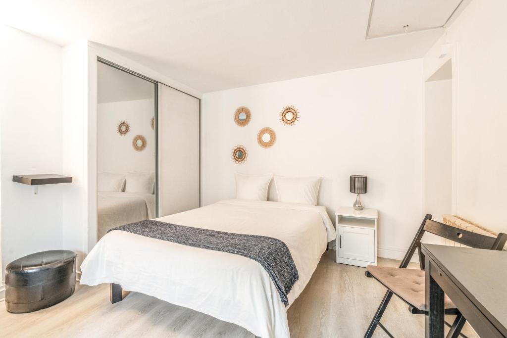 une chambre blanche avec un lit et une table dans l'établissement Chatelet Flat, à Paris