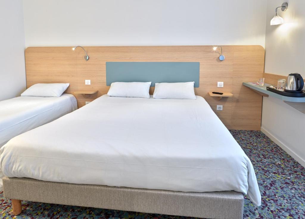 Postel nebo postele na pokoji v ubytování Hôtel REVOTEL Nancy Centre Gare et Congrès