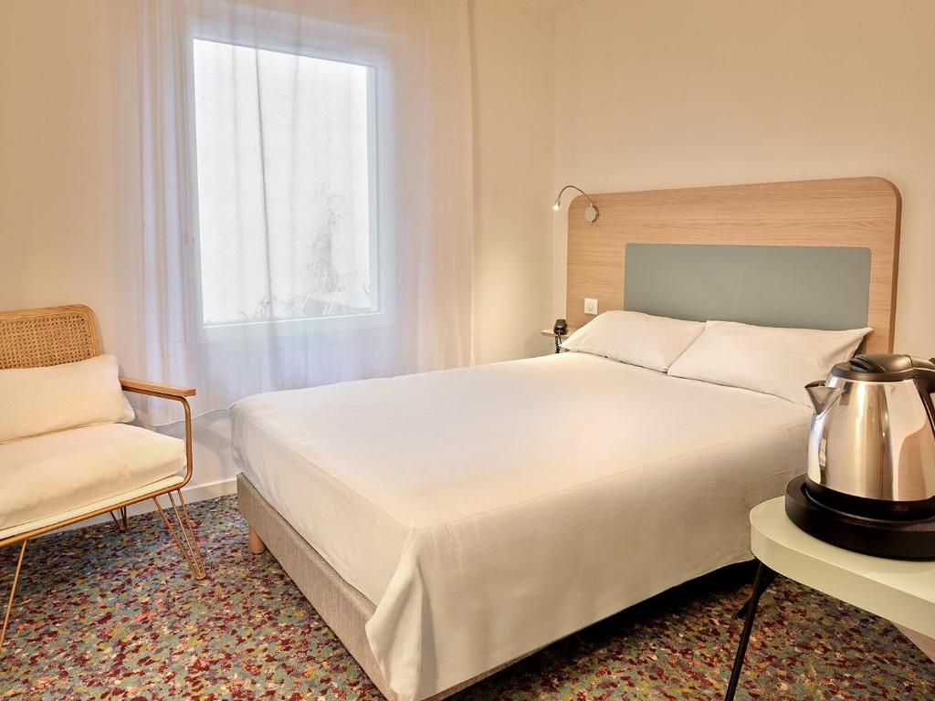 Postel nebo postele na pokoji v ubytování Hôtel REVOTEL Nancy Centre Gare et Congrès